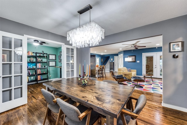 dining area featuring french doors, dark hardwood / wood-style flooring, ceiling fan with notable chandelier, and a textured ceiling