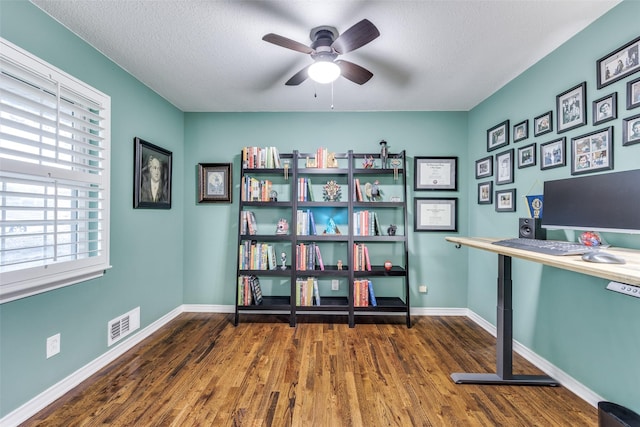 unfurnished office with ceiling fan, dark hardwood / wood-style floors, and a textured ceiling