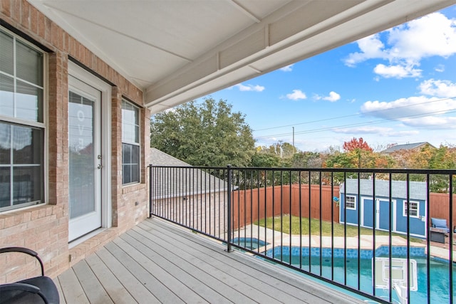 deck with a shed and a fenced in pool