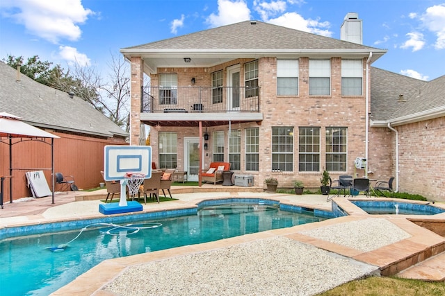 rear view of property with a patio area and a balcony