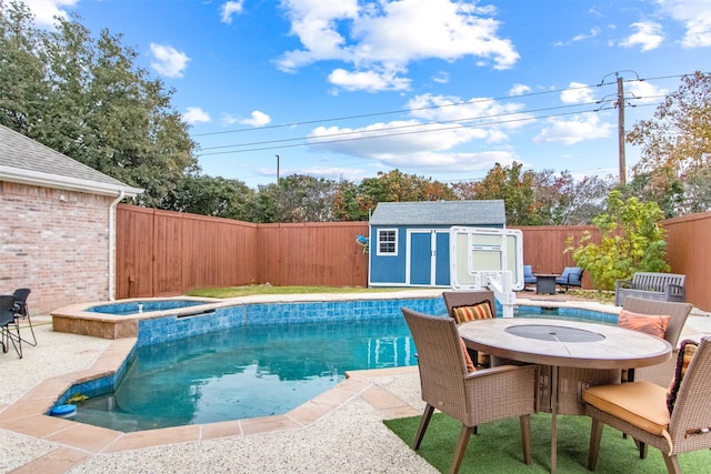 view of pool featuring an in ground hot tub, a patio, and a shed