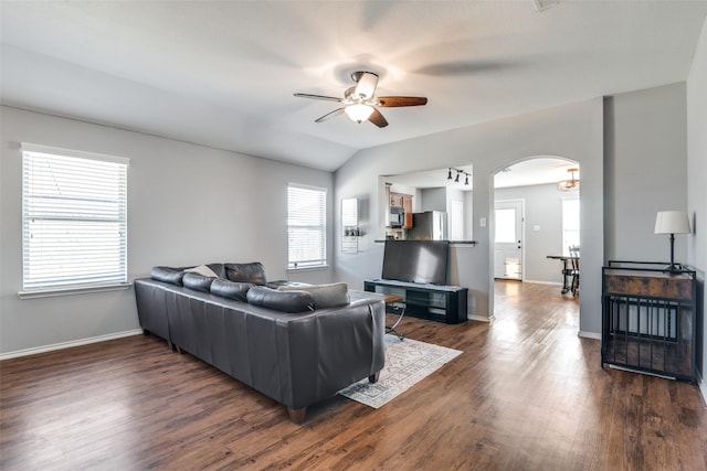 living room featuring ceiling fan, dark hardwood / wood-style floors, and vaulted ceiling