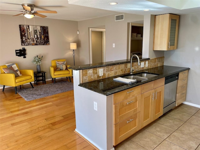 kitchen with dishwasher, sink, dark stone countertops, light hardwood / wood-style floors, and kitchen peninsula