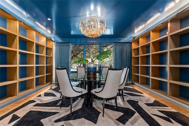 living area featuring an inviting chandelier, visible vents, and wood finished floors