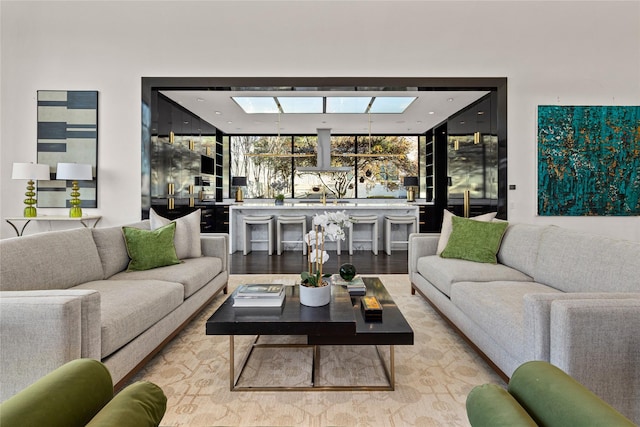 living room with light wood-type flooring and a skylight