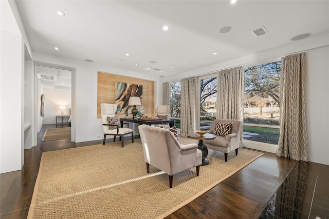 living area with wood finished floors, visible vents, and recessed lighting