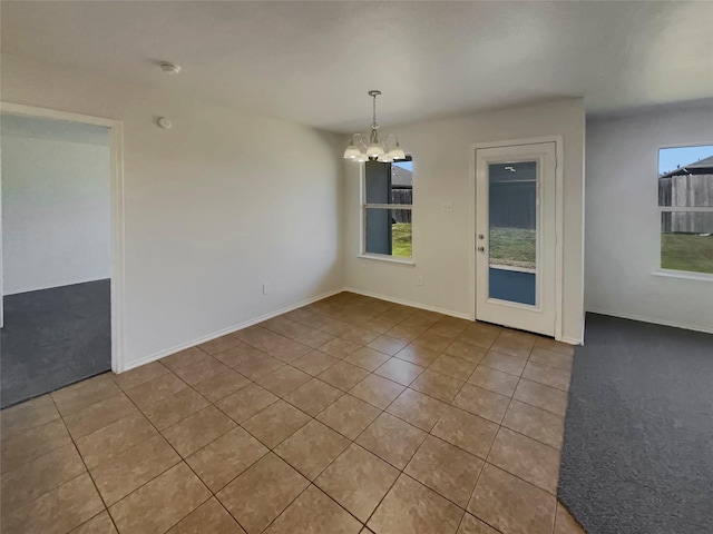 empty room featuring light tile patterned floors and a notable chandelier