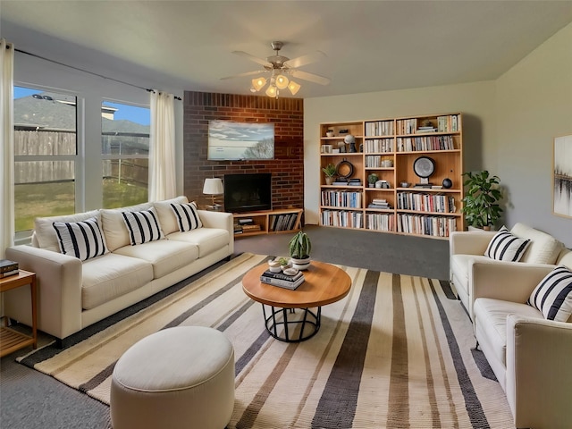 carpeted living room with a brick fireplace and ceiling fan