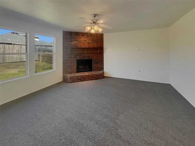 unfurnished living room featuring a brick fireplace, carpet floors, and ceiling fan