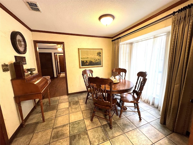 dining space with ornamental molding and a textured ceiling