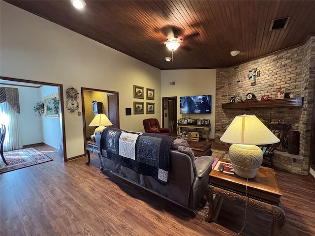 cinema room with lofted ceiling, wood ceiling, dark hardwood / wood-style flooring, and a brick fireplace