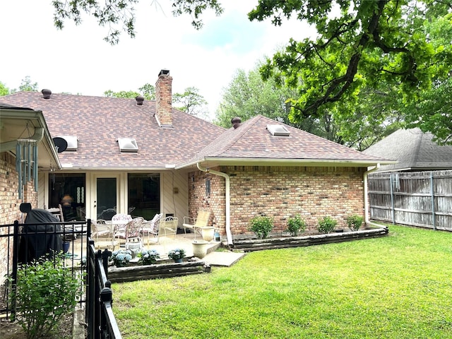 back of property with a yard and a patio area