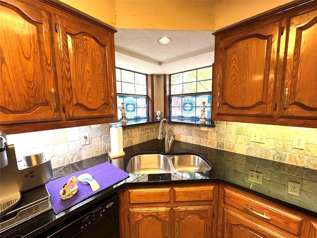 kitchen featuring tasteful backsplash, sink, black dishwasher, and a textured ceiling