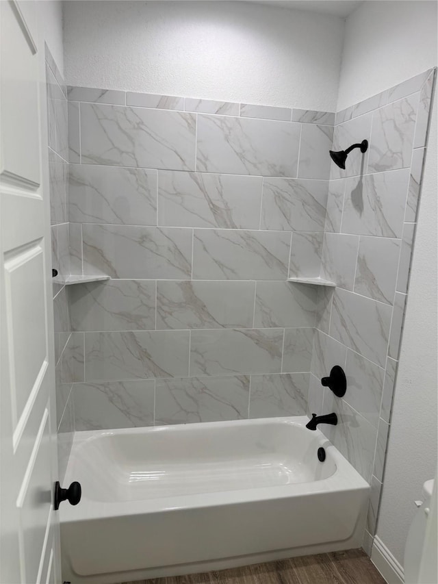 bathroom featuring tiled shower / bath and wood-type flooring