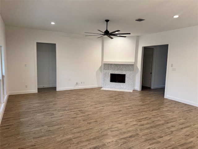 unfurnished living room with ceiling fan, wood-type flooring, and a fireplace