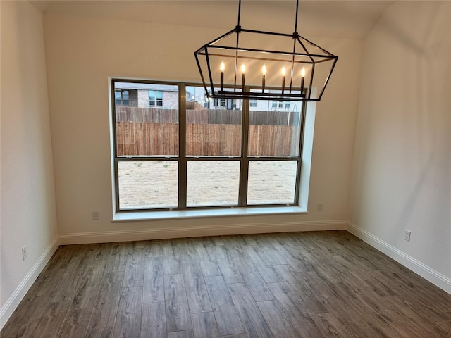 unfurnished dining area featuring hardwood / wood-style floors and an inviting chandelier