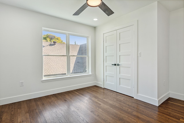 unfurnished bedroom featuring ceiling fan, dark hardwood / wood-style flooring, and a closet