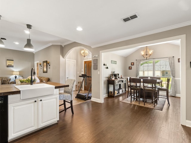 kitchen with white cabinetry, sink, a chandelier, and decorative light fixtures