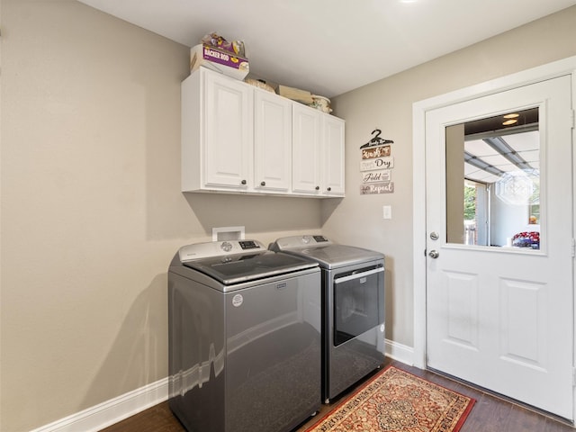 washroom featuring cabinets, dark wood-type flooring, and washing machine and clothes dryer