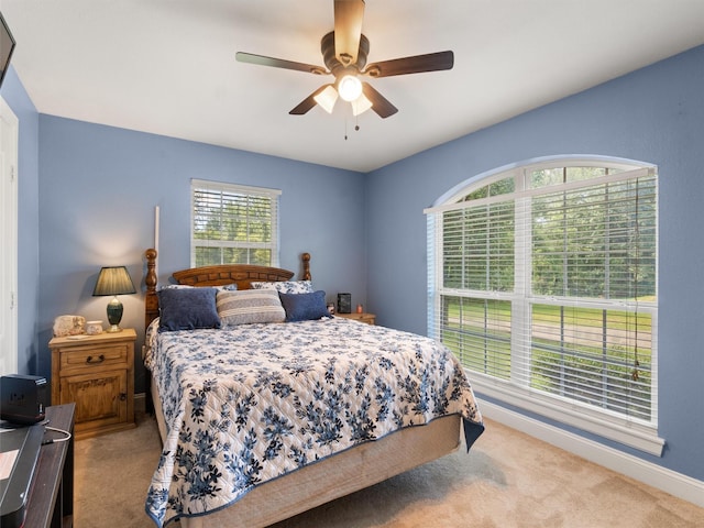 bedroom featuring light colored carpet and ceiling fan