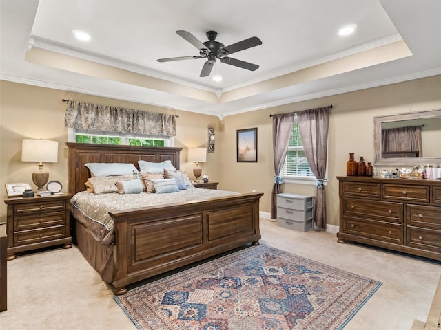 bedroom featuring light carpet, a tray ceiling, ornamental molding, and ceiling fan