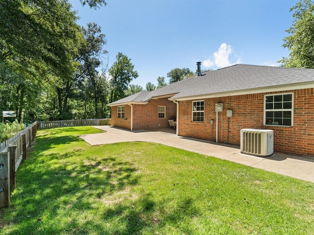 back of property featuring a yard, a patio area, and central air condition unit