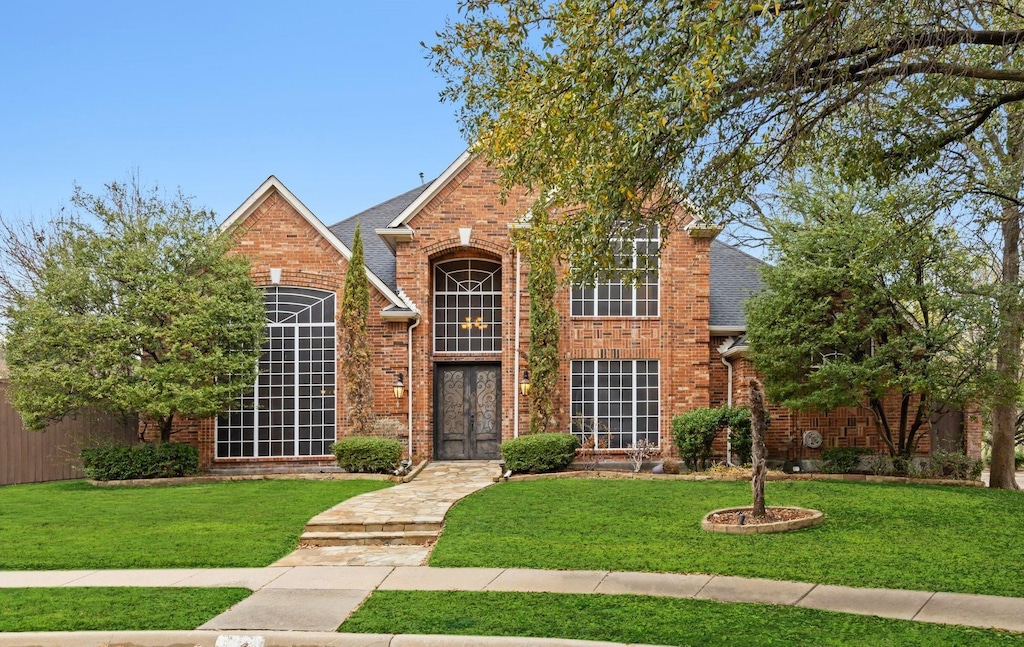 front facade featuring a front lawn and french doors