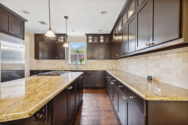 kitchen featuring stainless steel appliances, sink, pendant lighting, and dark brown cabinetry