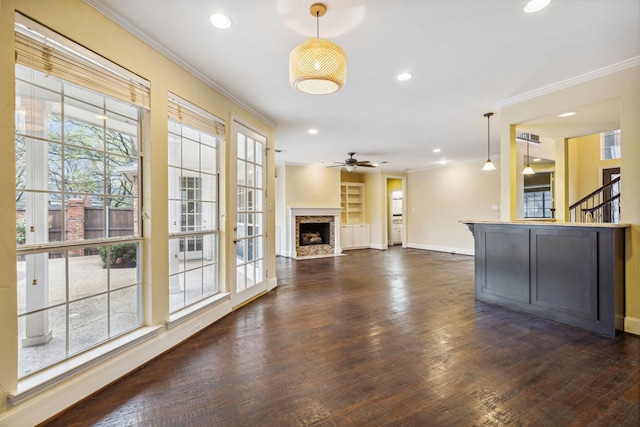 unfurnished living room featuring ornamental molding, ceiling fan, and dark hardwood / wood-style flooring