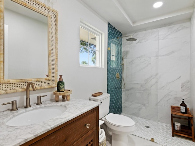 bathroom featuring vanity, toilet, and a tile shower