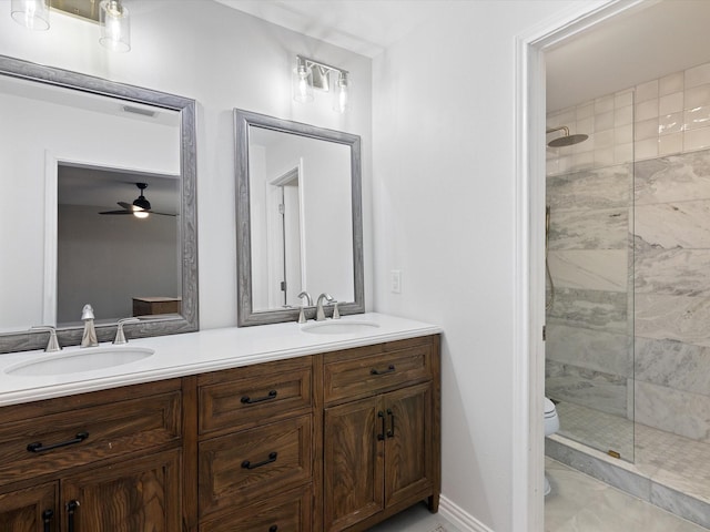 bathroom featuring vanity, toilet, and a tile shower