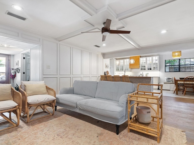 living room with ceiling fan, ornamental molding, and light hardwood / wood-style floors