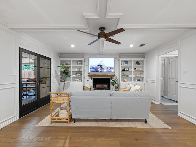 living room with built in shelves, french doors, ornamental molding, ceiling fan, and hardwood / wood-style floors