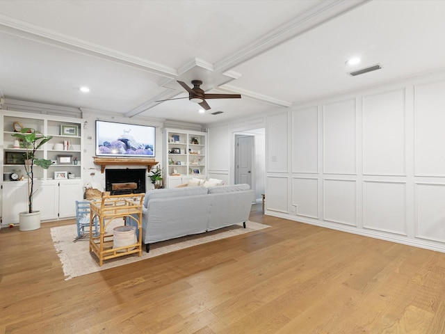 living room featuring ceiling fan, coffered ceiling, built in features, and light hardwood / wood-style floors