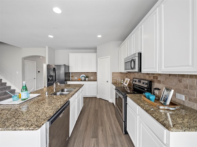 kitchen featuring dark stone countertops, sink, stainless steel appliances, and white cabinets