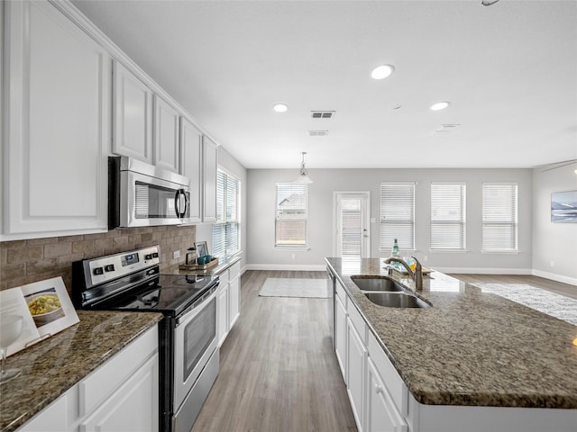 kitchen featuring appliances with stainless steel finishes, sink, white cabinets, and decorative backsplash