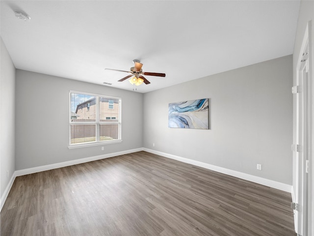 unfurnished room with ceiling fan and dark hardwood / wood-style flooring