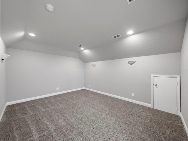 additional living space featuring vaulted ceiling and carpet