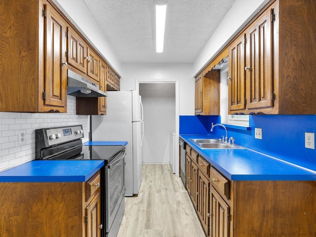 kitchen with sink, light wood-type flooring, decorative backsplash, a textured ceiling, and electric stove