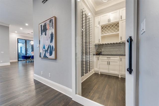 hallway with ornamental molding and dark hardwood / wood-style floors