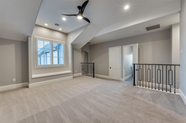 additional living space with light carpet and ceiling fan