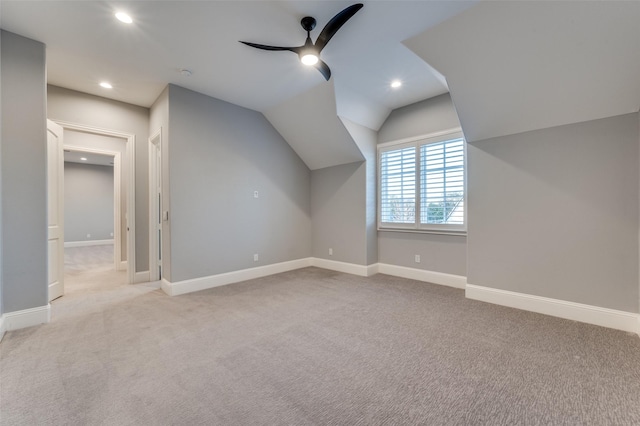 additional living space with vaulted ceiling, light colored carpet, and ceiling fan