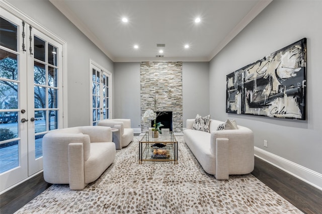 living room with french doors, a fireplace, crown molding, and hardwood / wood-style floors