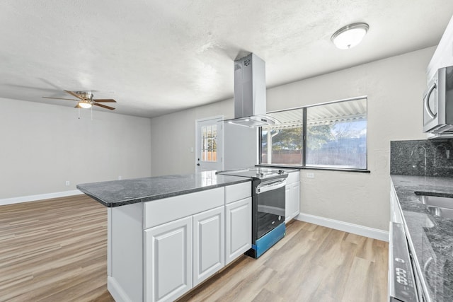 kitchen featuring island range hood, light wood-type flooring, kitchen peninsula, stainless steel appliances, and white cabinets