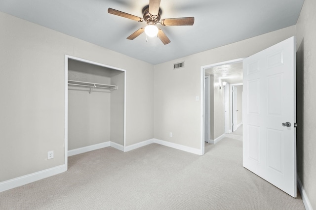 unfurnished bedroom featuring light carpet, ceiling fan, and a closet