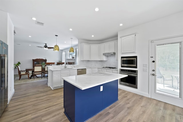 kitchen featuring white cabinetry, a center island, kitchen peninsula, pendant lighting, and stainless steel appliances