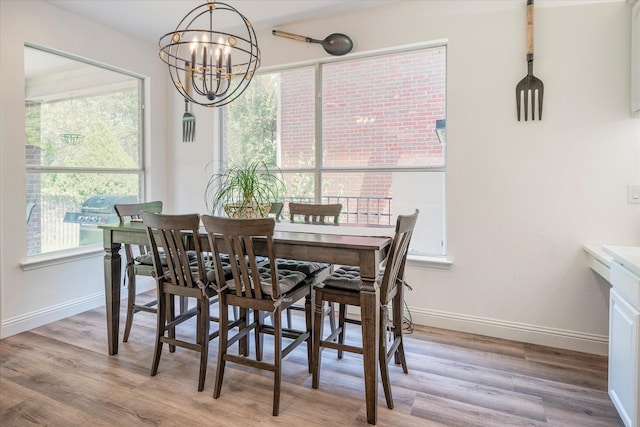 dining area with a notable chandelier and light hardwood / wood-style floors