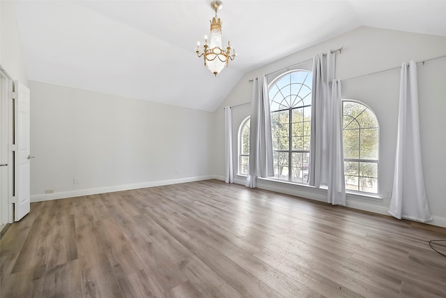 interior space with lofted ceiling, hardwood / wood-style floors, and a notable chandelier