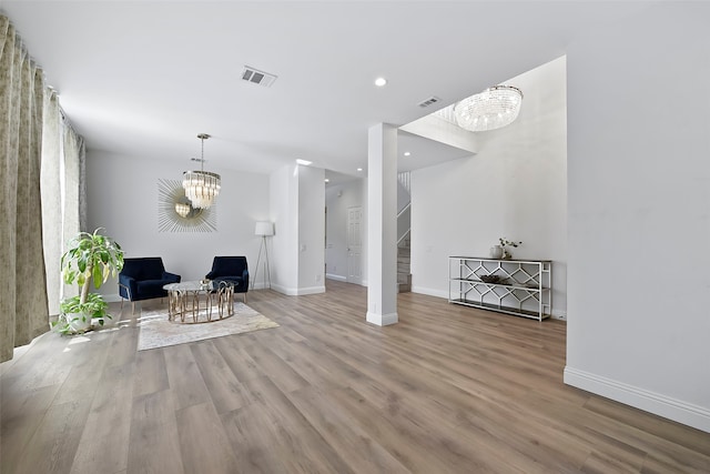 unfurnished room with an inviting chandelier and light wood-type flooring