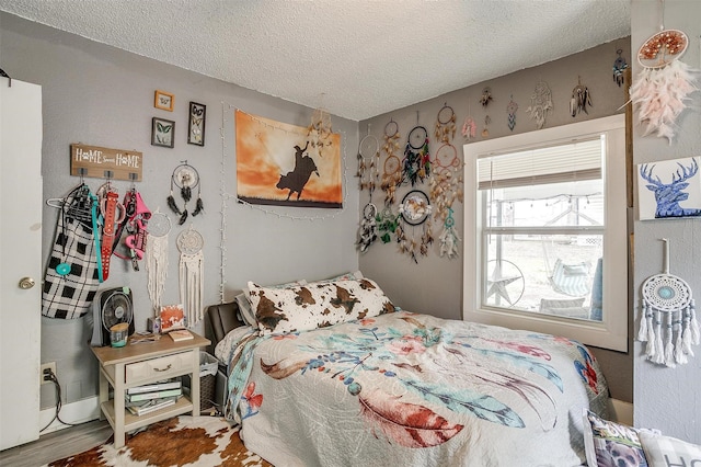 bedroom with wood-type flooring and a textured ceiling